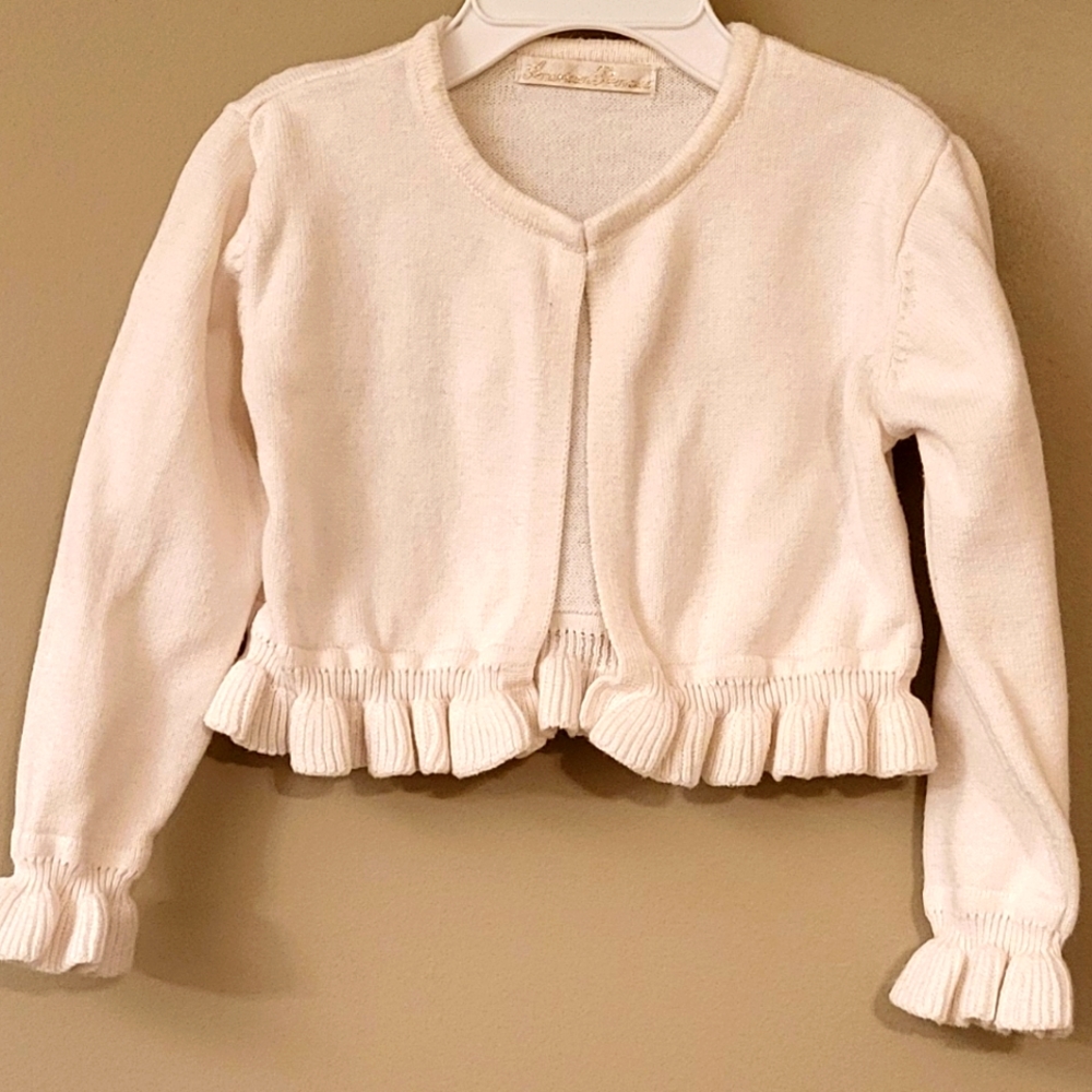 Adorable ivory sweater with bottom and cuff frills